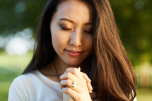 a woman in prayer outdoors 