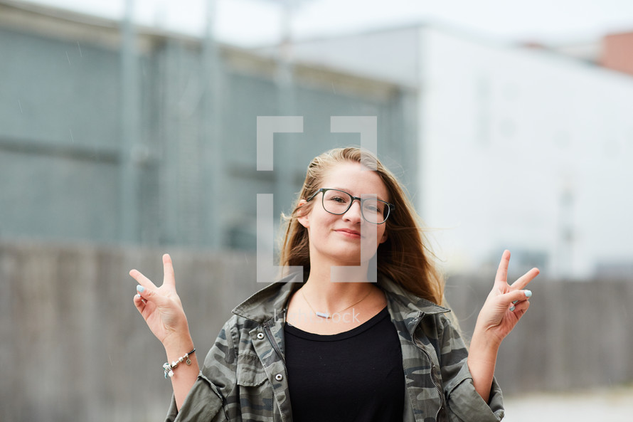 teen girl flashing peace signs 