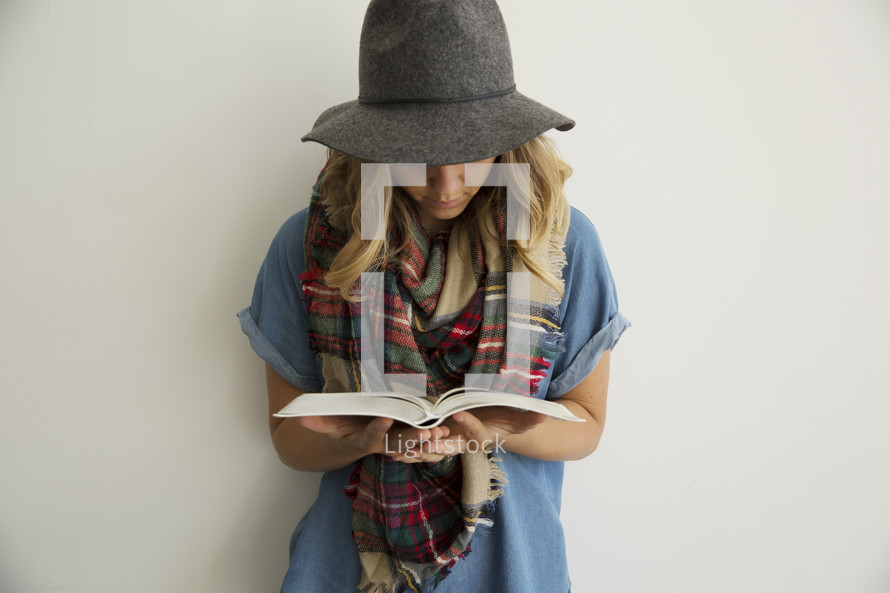 a woman in plaid shaw reading a Bible 