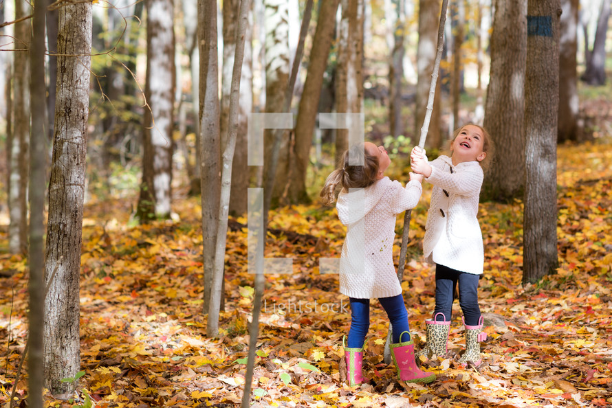 children playing in fall leaves 
