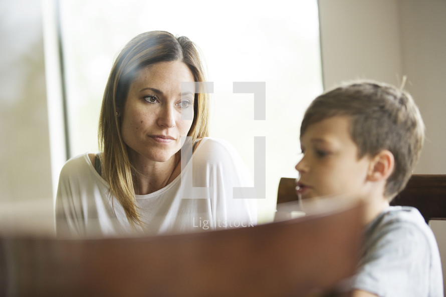 mother intentionally looking at her son at the kitchen table 