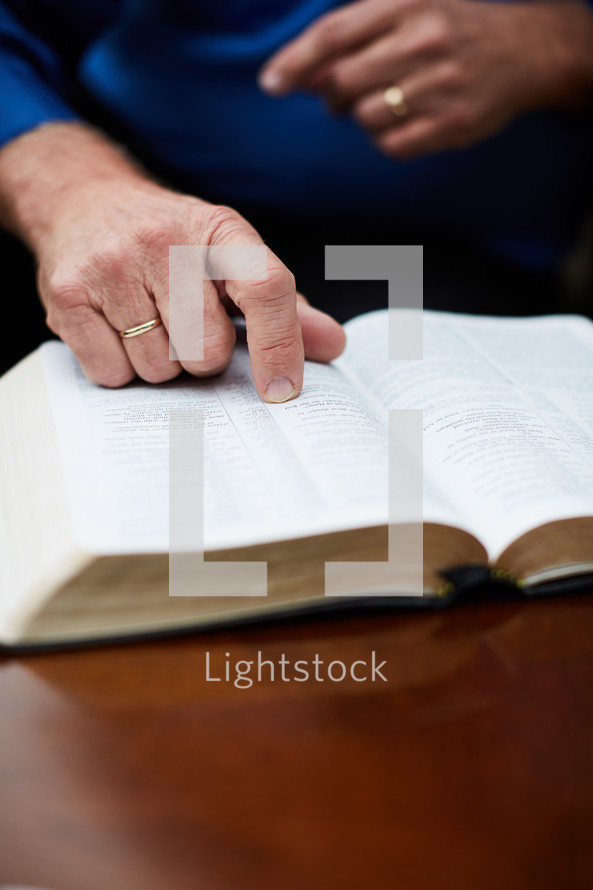 elderly man with finger pointing to scripture 
