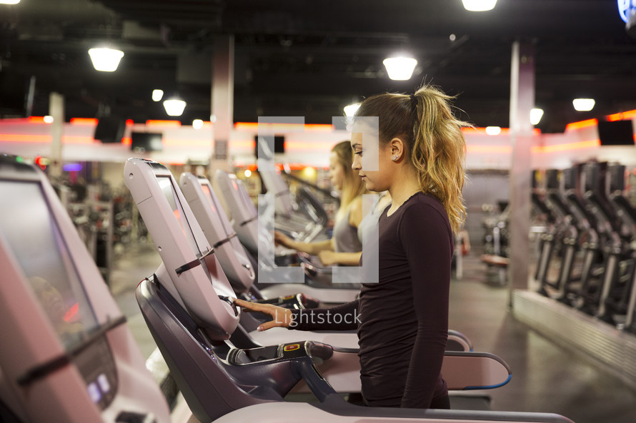 women walking on treadmills at the gym