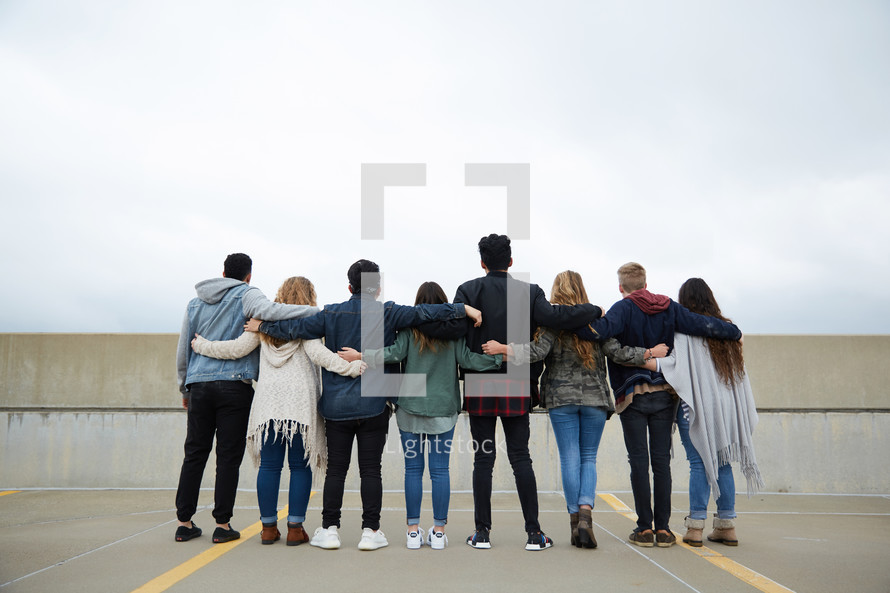group of teens with arms around each other 