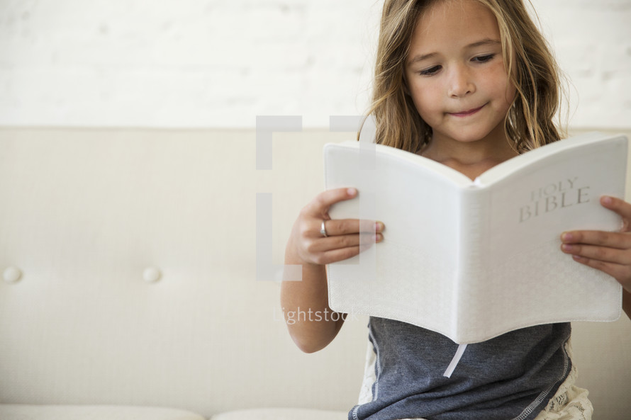 a girl child reading a Bible 