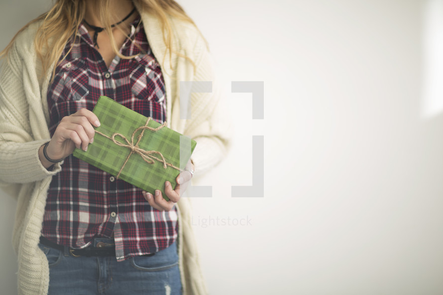 torso of a woman holding a Christmas gift 