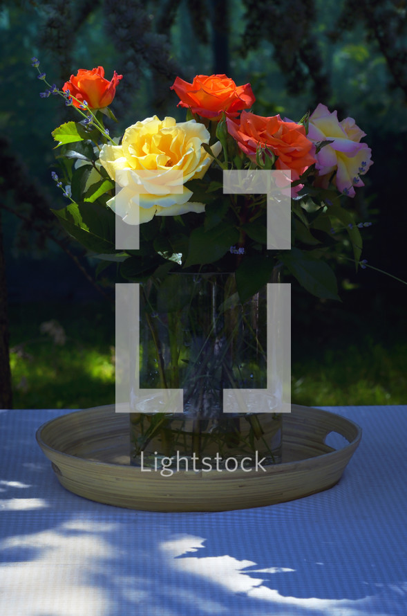 Roses in Vase on Table in Summer Garden