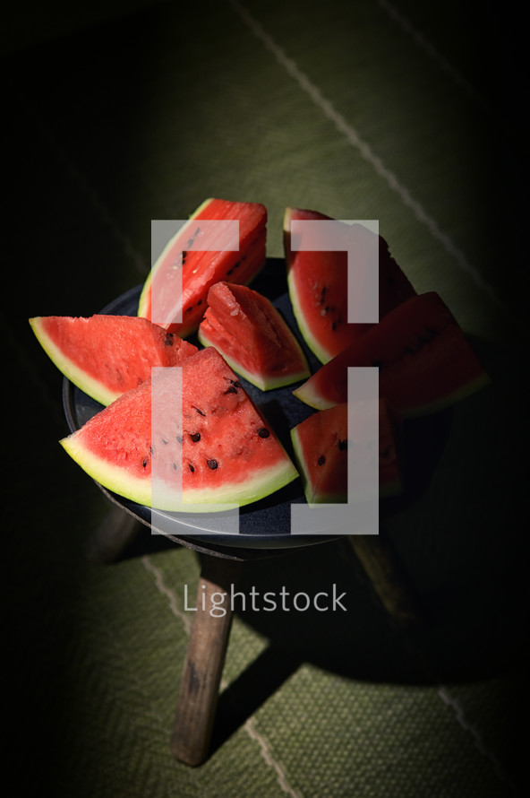Sliced watermelon on a plate and old chair with natural light