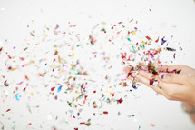 a woman blowing colorful confetti 