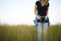 a young woman standing in a field of tall grass