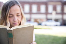 woman reading a book outdoors 