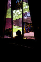 woman in front of a stained glass window 