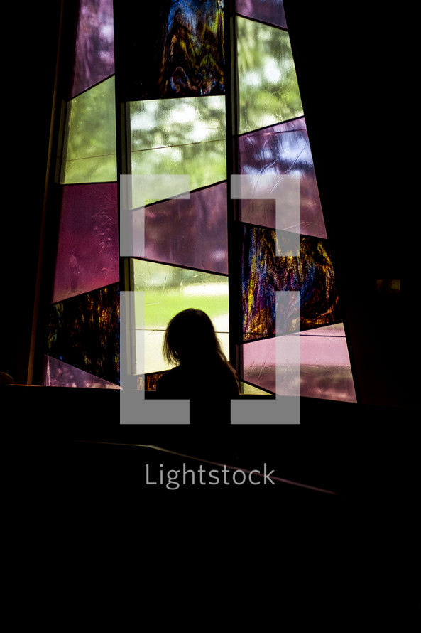 woman in front of a stained glass window 