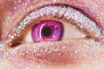 Macro violet or pink female eye with glitter eyeshadow, colorful sparks, crystals. Beauty background, fashion glamour makeup concept. Fantasy look. 
