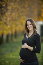 smiling pregnant woman with her hands on her belly