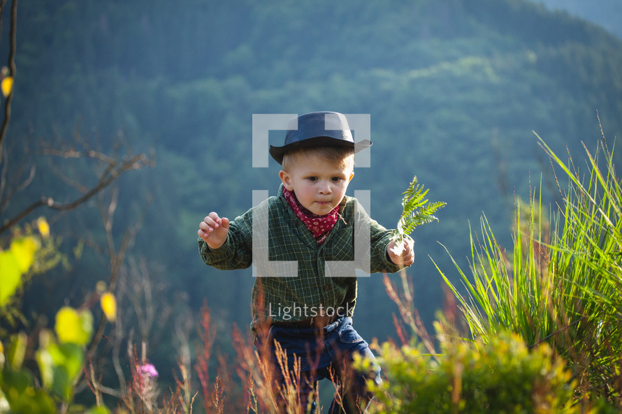 Cute Little Boy with Hat and Bandana in Beautiful Mountains
