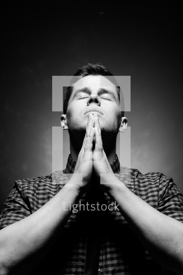 man with praying hands in prayer to God