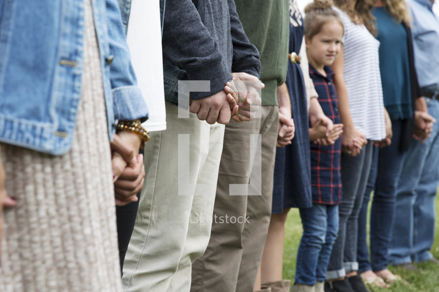 family holding hands in a circle in prayer 