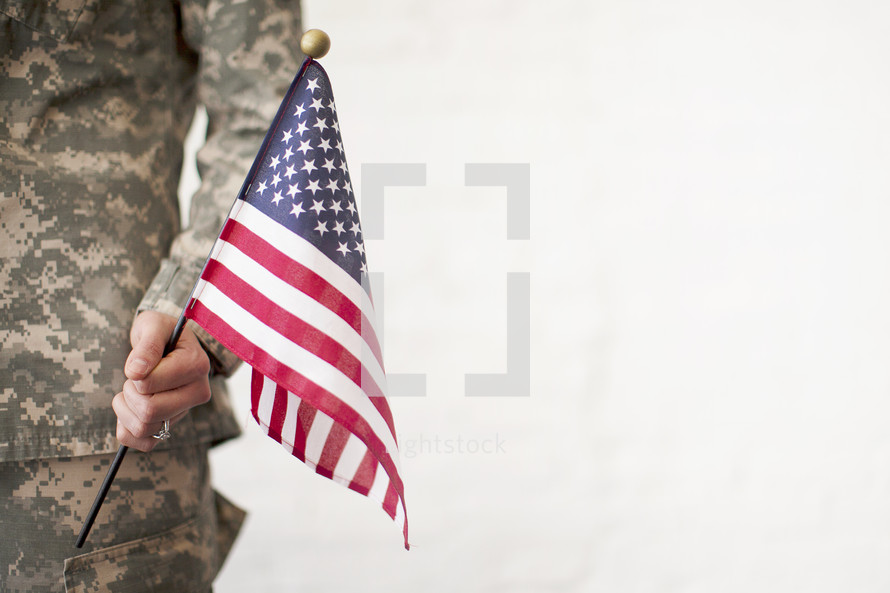 A soldier holds an American flag.