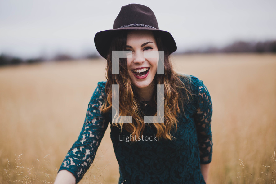 a joyful woman outdoors in a field 