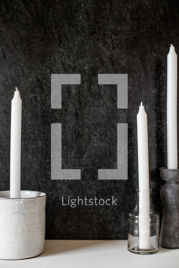 white candles against a black background 