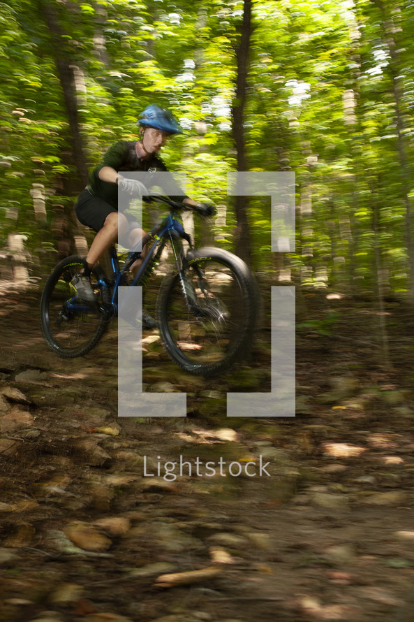 boy riding a bicycle in a forest 