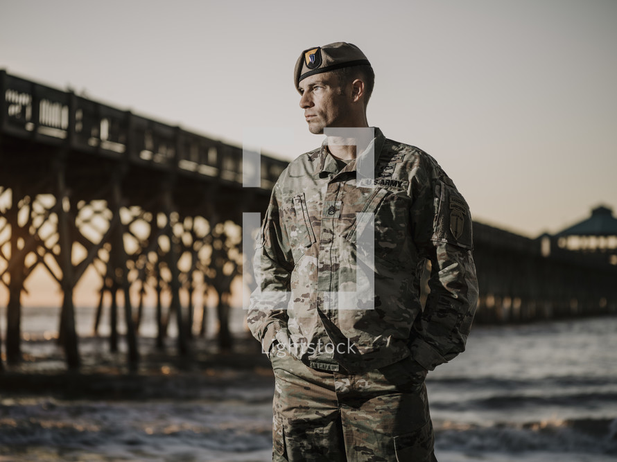 portrait of a soldier by a pier at a beach 