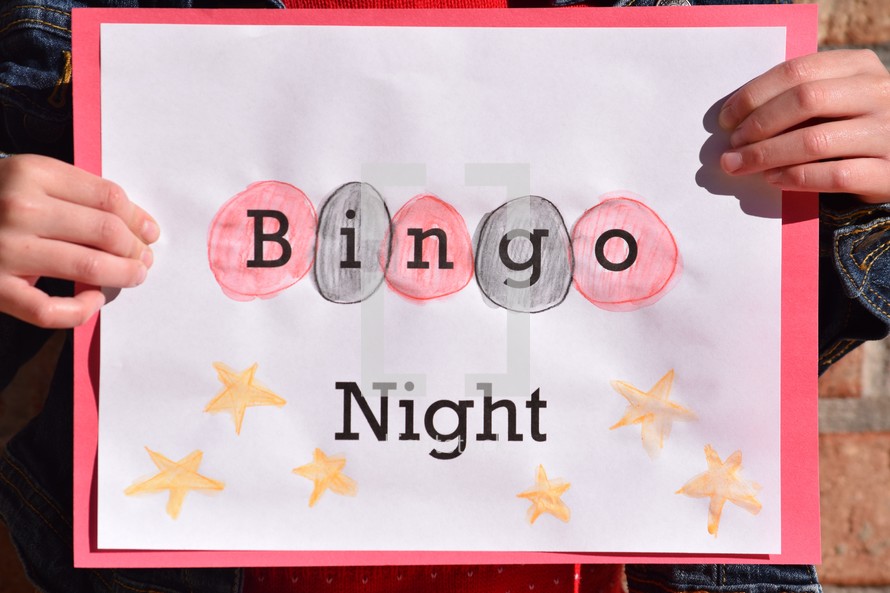 A girl holding a Bingo Night sign 