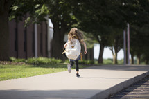 a little girl running to school 