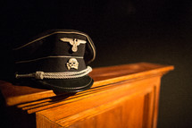 Captain's hat on the edge of a wooden table.