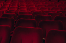 Rows of seating in a theatre or cinema, red chairs