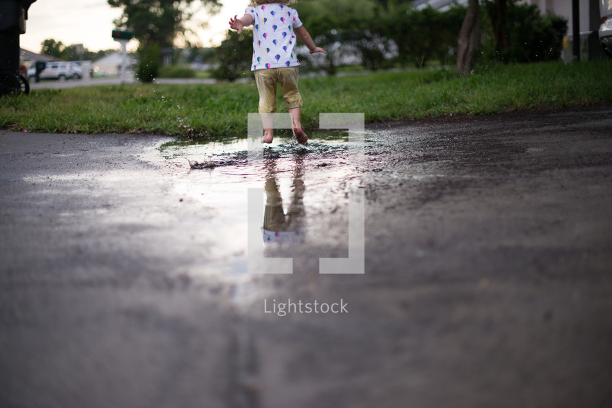 toddler girl running through a puddle 