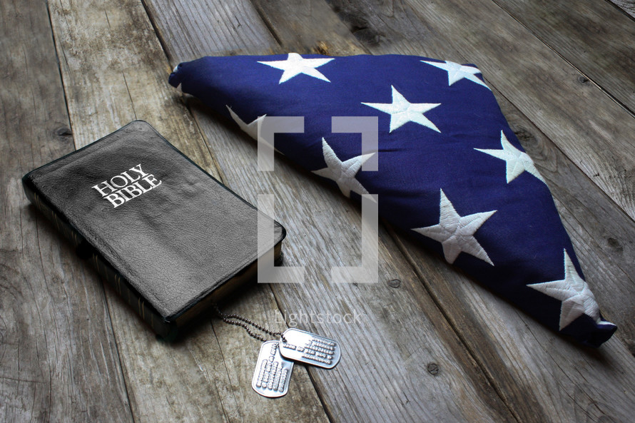 Folded American flag, dog tags, and Bible 
