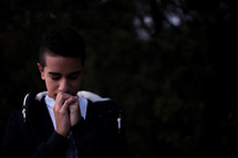 teen boy with praying hands 