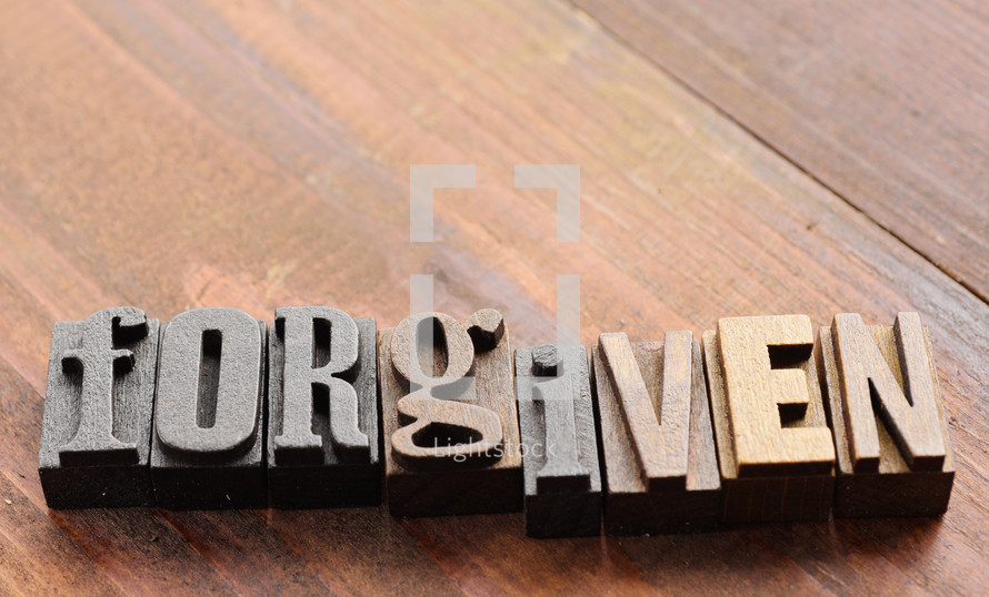 The word "forgiven" spelled out with old letter press letters.