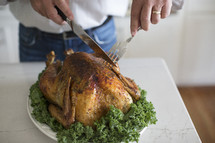 a man carving a Thanksgiving turkey 