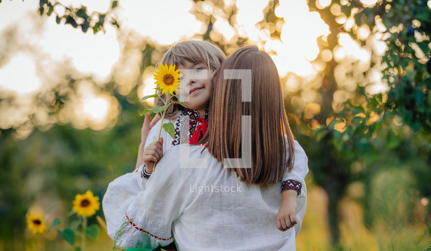Tender scene of loving son with mom on apple garden backdrop with sunlight. Beautiful family. Cute 4 years old kid with mother. Parenthood, childhood, happiness, children wellbeing concept.