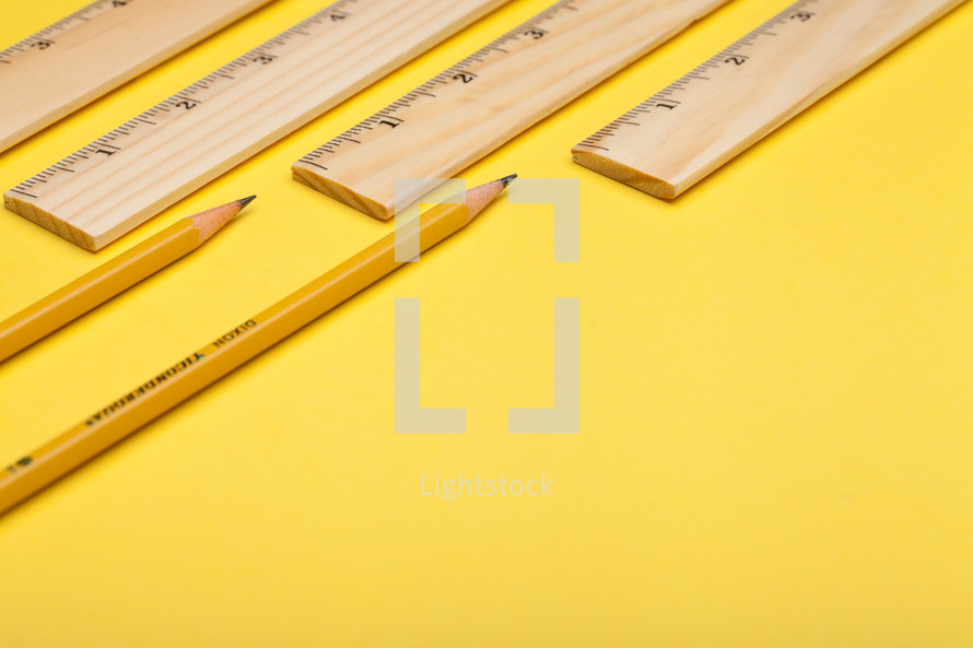 rulers and pencils on a yellow background 
