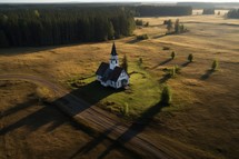Aerial view of a small church in the middle of a field.