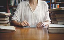 a woman sitting at a table in a library 