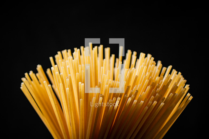 A pile of spaghetti dry on the table. Against a dark background. High quality photo