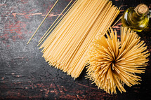 A pile of spaghetti dry on the table. Against a dark background. High quality photo