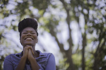 An African American woman praying outdoors 