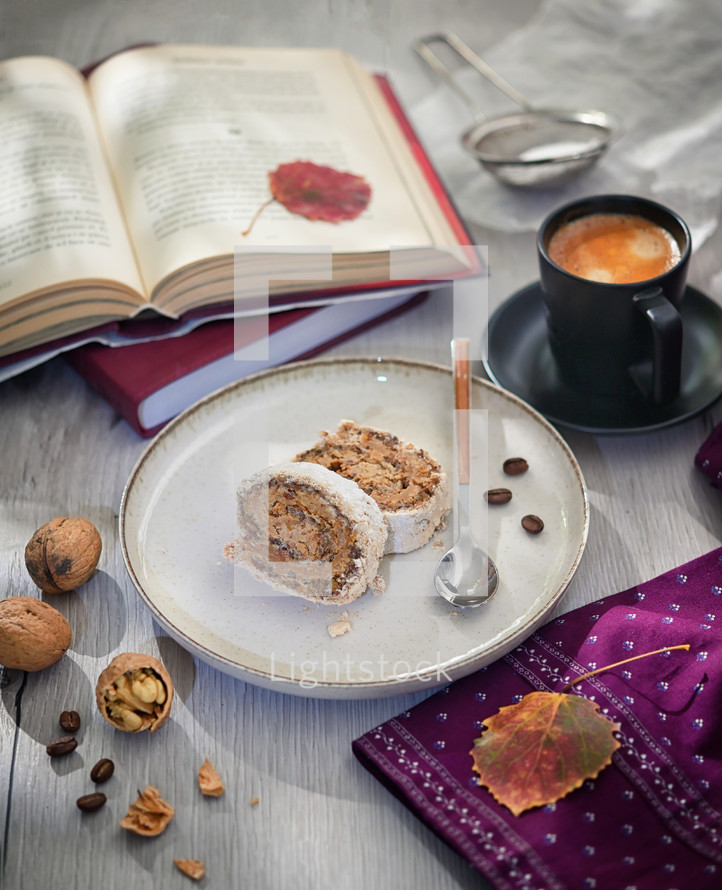 A cozy fall scene with book, dessert, walnut, and leaves