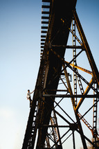 a man climbing a rusty bridge 