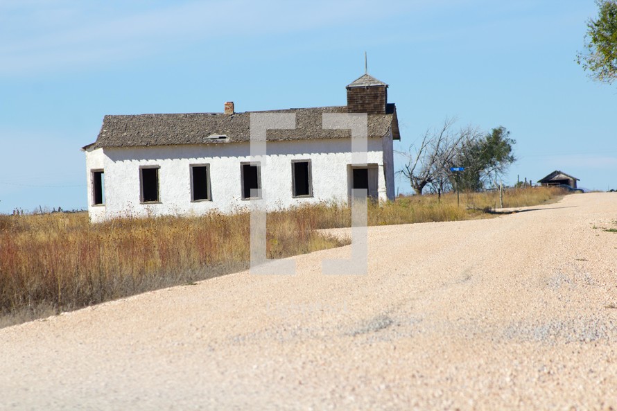 a small abandoned church and gravel road 