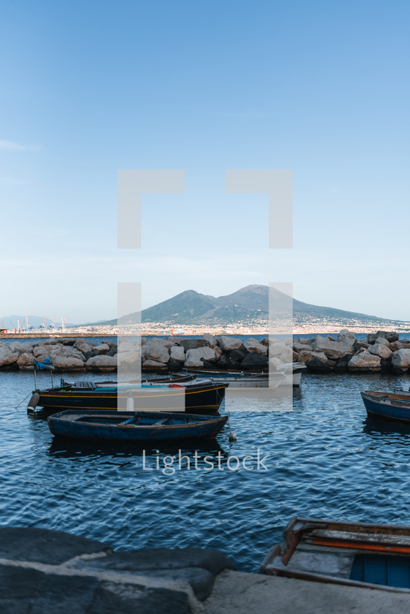 boats moored in the sea with Vesuvius in the background