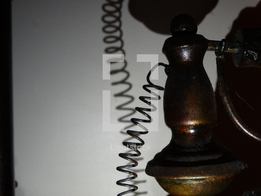 Abstract image of an old telephone casting shadow against white wall in dark lighting