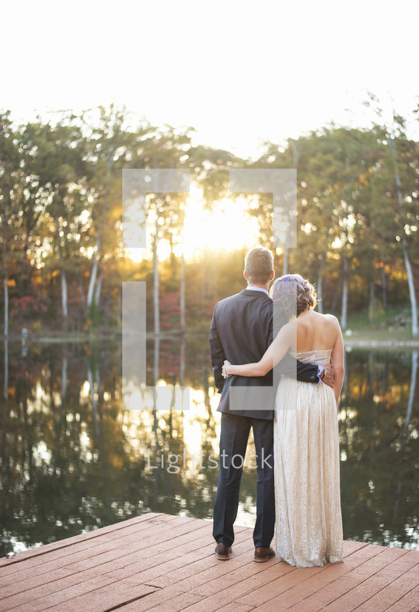 bride and groom standing on a dock 