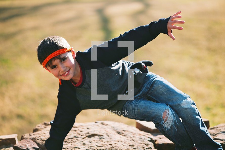 a boy child climbing rocks outdoors 